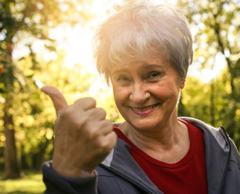 Older woman holding thumb up