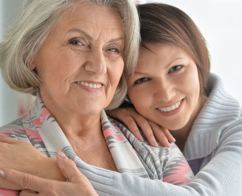 Young woman hugging older adult woman