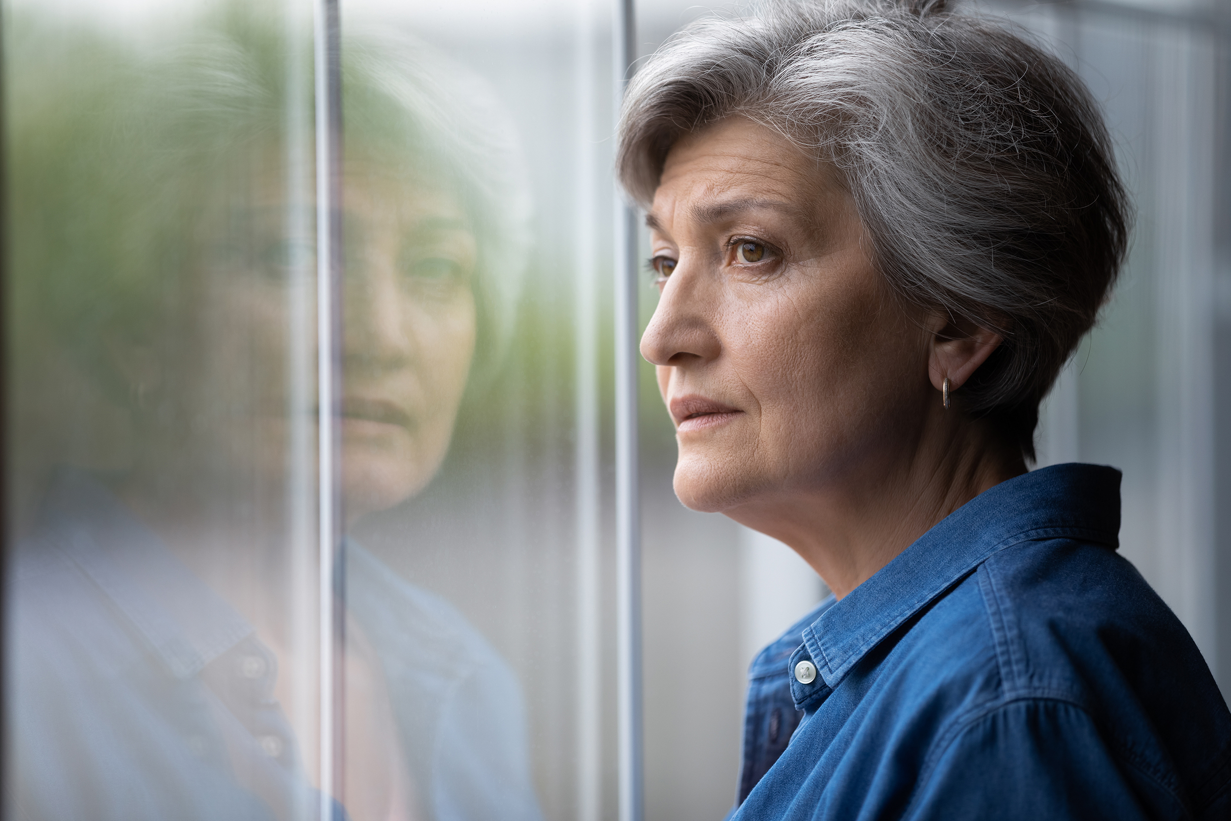 Concerned woman looking out window